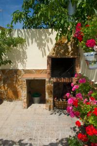 an outdoor pizza oven with flowers in a courtyard at Casa Rural Maria Belen in Ruidera