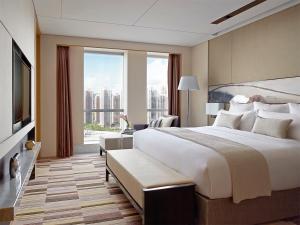 a bedroom with a large bed and a large window at Langham Place Xiamen in Xiamen