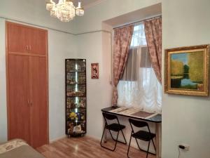 um quarto com uma mesa e cadeiras e uma janela em Apartment On Knyazya Romana 26 Center Lviv em Lviv