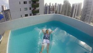 un hombre montando una ola en una piscina en Apartamento Alice Tenório, en Recife