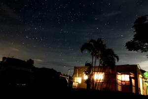 名護市にあるゲストハウス 笑縁門の椰子の木とトラックの星空