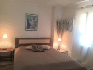 een slaapkamer met een bed met 2 tafels en 2 lampen bij Les Hameaux de Propriano in Propriano