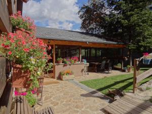 a patio with flowers and a house at Xalet Refugi Pere Carné in La Molina