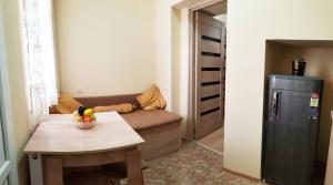 um pequeno quarto com uma mesa e um sofá em Apartament Old Avlabar em Tbilisi
