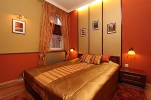 a bedroom with a bed with orange walls and a window at Mirage Apartment in Hévíz
