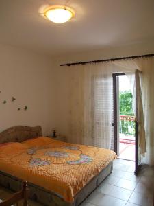 a bedroom with a bed and a sliding glass door at Apartment Jelaca in Herceg-Novi