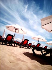 una fila di sedie e ombrelloni su una spiaggia di Santa Sofia Studio a Sunny Beach