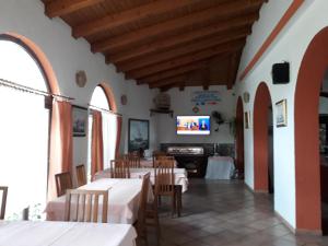 a restaurant with tables and chairs and a tv at San Lorenzo in Lopar