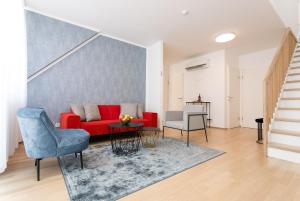 salon z czerwoną kanapą i niebieskim krzesłem w obiekcie Mar Suite Apartments - Center w Wiedniu