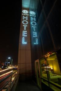 un edificio con un'insegna al neon di notte di Hotel Halwachy a As Sulaymānīyah