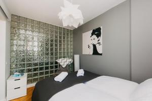 ワルシャワにあるShortStayPoland Mokotowska (B60)の白いベッドとガラスの壁が備わるベッドルーム1室が備わります。