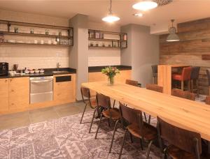 a kitchen with a long wooden table and chairs at Coffee Fellows Hotel Dortmund in Dortmund