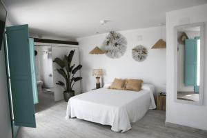 a white bedroom with a bed and a mirror at Respirar in Peniscola