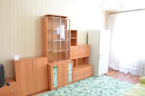 トヴェリにあるApartamenty v tsentreの木製のキャビネットと冷蔵庫が備わる客室です。