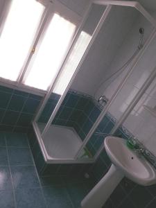 ein Bad mit einem Waschbecken, einer Dusche und einem Spiegel in der Unterkunft Favilla üdülőház in Bogács