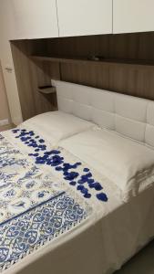 a bed with a blue and white blanket on it at La casetta di Alfina in Mascali