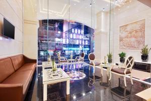 a lobby with a couch and tables and chairs at Mercury Boutique Hotel & Apartment Da Nang in Danang