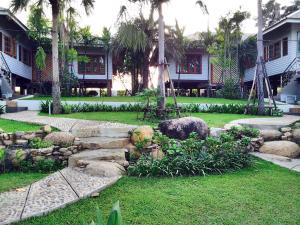 un jardín con rocas y plantas frente a una casa en Magmai Riverside, en Tak