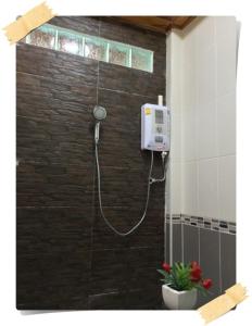 una ducha con una manguera pegada a una pared de ladrillo en Magmai Riverside, en Tak