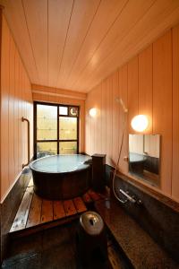 a bathroom with a bath tub in a room at Ryokan Tamura in Kusatsu