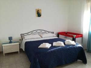 a bedroom with a blue bed with towels on it at Sunset Flat in Isola delle Femmine