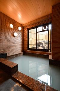 a swimming pool in a room with a window at Ryokan Tamura in Kusatsu