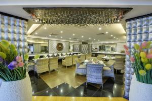 un ristorante con tavoli, sedie e fiori di Mayfair Convention a Bhubaneshwar