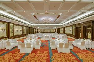 une salle de banquet avec des tables blanches et des chaises blanches dans l'établissement Mayfair Convention, à Bhubaneswar