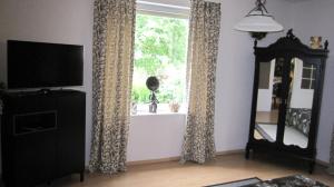 a living room with a television and a window at Am Living Garden in Bad Pyrmont