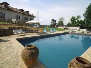 a swimming pool with a large vase next to a house at La Morona in Rocchetta Tanaro