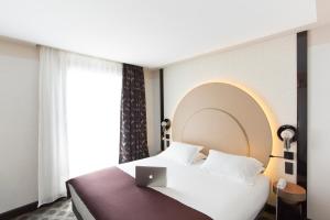 um quarto com uma cama com um computador portátil em Hôtel Cannes Centre Univers em Cannes