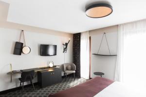 a bedroom with a desk and chairs in a room at Hôtel Cannes Centre Univers in Cannes