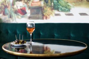 szklankę wina i miskę oliwek na stole w obiekcie Hôtel Cannes Centre Univers w Cannes