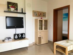 a living room with a flat screen tv on a wall at Apartment Noel in Novalja