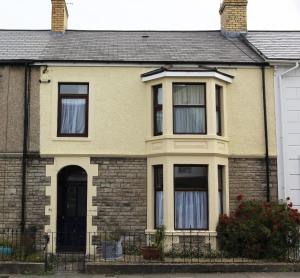 a yellow brick house with a black door at 81 Eastgate in Cowbridge