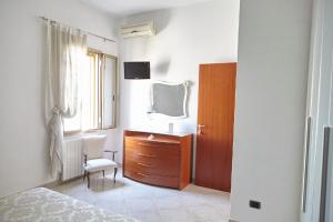 1 dormitorio con cama, tocador y espejo en Baciata Dal Sole Home en Monopoli