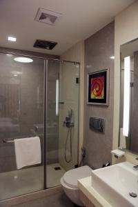 a bathroom with a shower and a toilet and a sink at Residency Hotel Fort in Mumbai