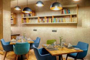 jadalnia z 2 stołami i niebieskimi krzesłami w obiekcie Focus Hotel Premium Sopot w mieście Sopot