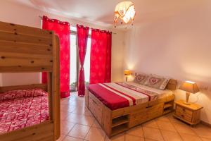 1 Schlafzimmer mit 2 Betten und einem Fenster mit roten Vorhängen in der Unterkunft Vistarelax in Aosta