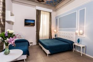 Boutique Hotel La Casa di Morfeo في فلورنسا: غرفة نوم بسرير وطاولة مع إناء من الزهور