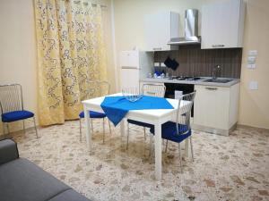 パルティニーコにあるSi Viaggiare Apartmentsのキッチン(テーブル、椅子、青いテーブルクロス付)