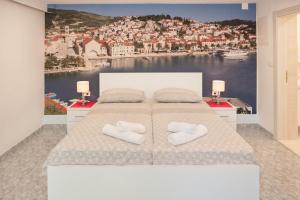 a bedroom with a bed with a view of a city at Apartments Majić in Hvar