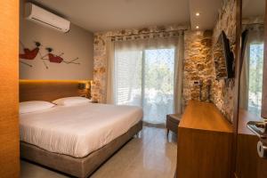 sypialnia z łóżkiem i dużym oknem w obiekcie AA Luxury Villas w Kato Daratso