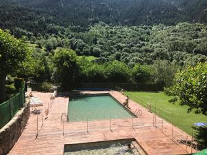 a swimming pool in the middle of a lawn with trees at Camping Aneto in Benasque