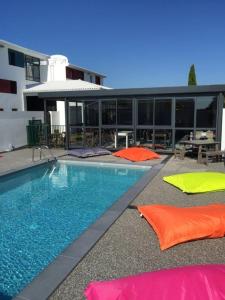 a swimming pool with colorful pillows in front of a building at detente rochelaise in Aytré