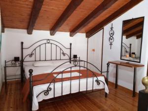 ein Schlafzimmer mit einem Metallbett und einer Holzdecke in der Unterkunft Iron House in Agios Georgios