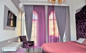 a bedroom with a red bed and purple curtains at Kiev City Center in Kyiv