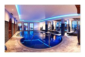 a large swimming pool in a hotel with blue lighting at Appartement Wildspitz' in Vent
