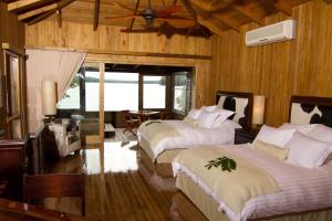 1 dormitorio con 2 camas y ventilador de techo en Las Lagunas Boutique Hotel en Flores