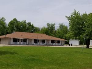 a building with a grass field in front of it at Pinawa Motel in Pinawa